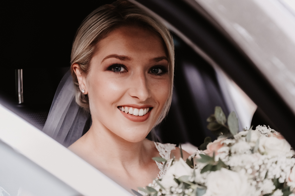 Braut sitzt im Auto-Hochzeitsfotografie