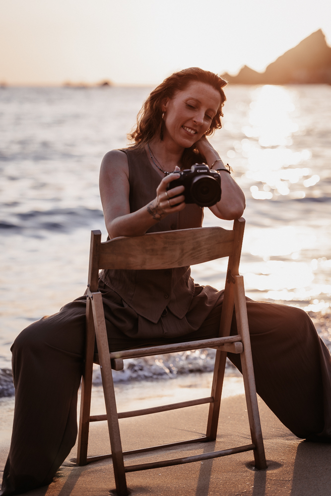 Hochzeitsfotografin Melanie Gobbetto auf einem Stuhl im Wasser am Meer im Sonnenuntergang